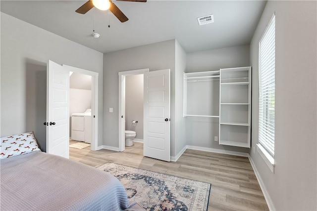293 W Ash St Unit 1, Fayetteville, AR 72703 - bedroom with separate washer and dryer, light wood-style floors, baseboards, and ensuite bathroom