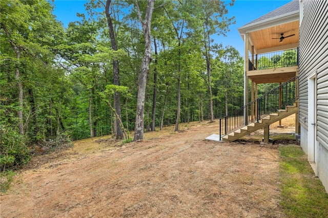 17 Winters Dr, Bella Vista, AR 72714 - view of yard with stairs, a ceiling fan, a deck, and a view of trees