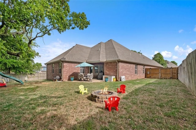 rear view of house featuring a fire pit, brick siding, a patio area, and roof with shingles