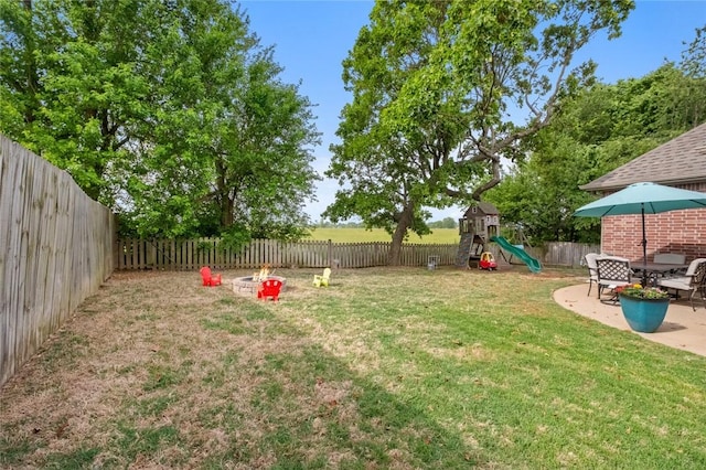 view of yard featuring a playground and a patio