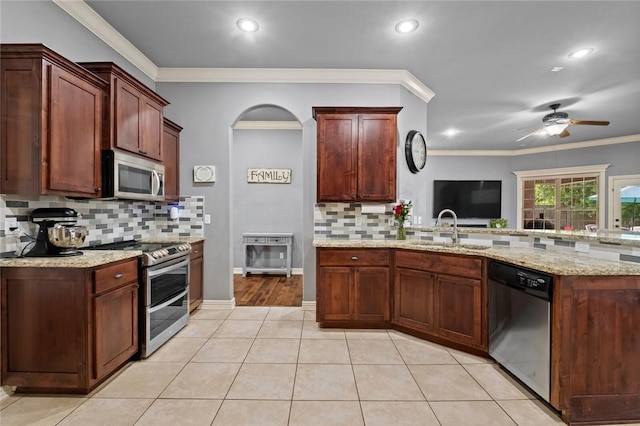 kitchen featuring stainless steel appliances, a sink, backsplash, ceiling fan, and recessed lighting