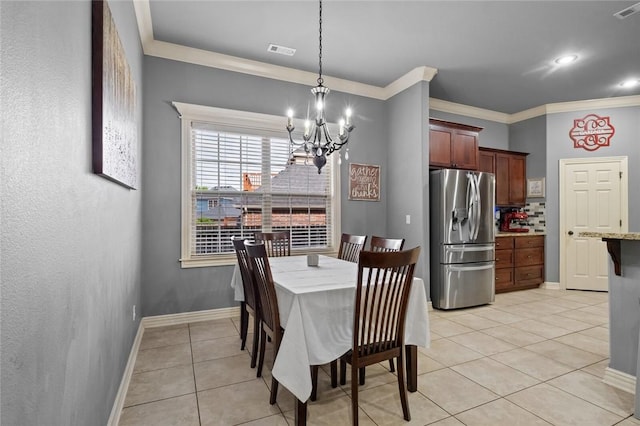 dining space featuring a chandelier, crown molding, light tile patterned floors, and baseboards