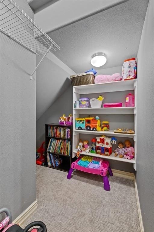 rec room with vaulted ceiling, carpet floors, and baseboards