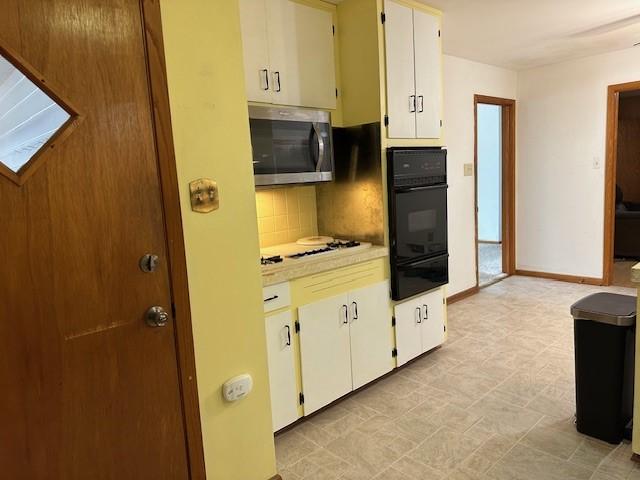 420 Natchez Trace Dr, Harrison, AR 72601 - kitchen featuring stainless steel microwave, black oven, a warming drawer, decorative backsplash, and white stovetop