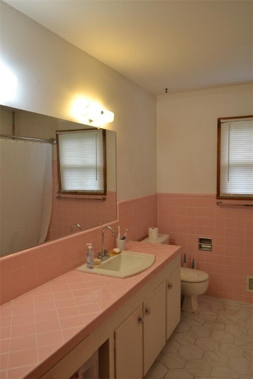 420 Natchez Trace Dr, Harrison, AR 72601 - full bath featuring tile walls, vanity, tile patterned flooring, wainscoting, and a shower with curtain