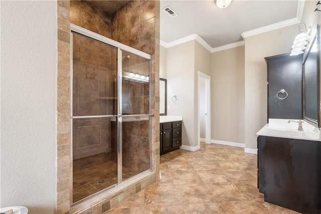 bathroom with vanity, a shower stall, ornamental molding, and baseboards