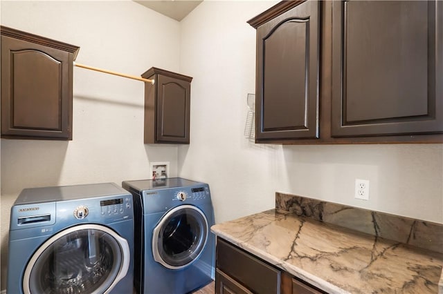 clothes washing area featuring cabinet space and independent washer and dryer