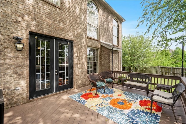 wooden deck with fence, an outdoor living space, and french doors