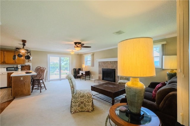 18880 Skylight Mountain Rd, Canehill, AR 72717 - living room featuring crown molding, plenty of natural light, a ceiling fan, light colored carpet, and a tile fireplace