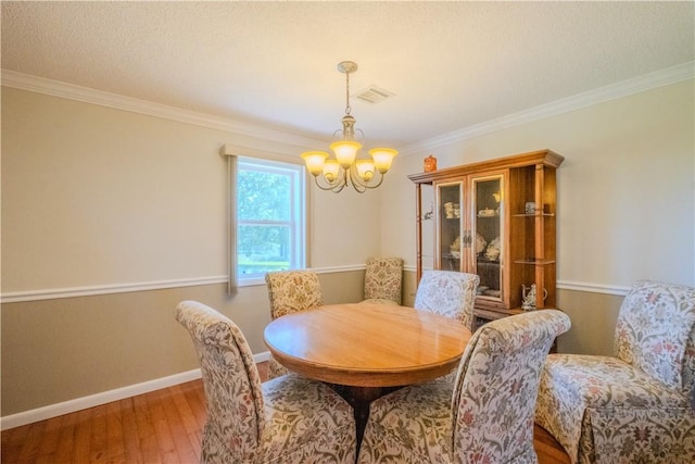18880 Skylight Mountain Rd, Canehill, AR 72717 - dining area featuring a chandelier, wood-type flooring, crown molding, and baseboards