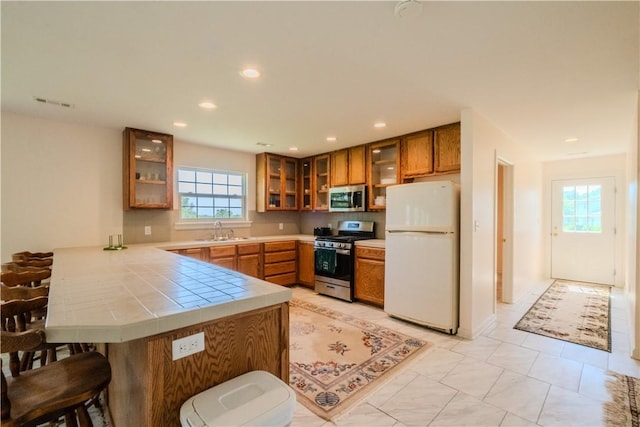 18880 Skylight Mountain Rd, Canehill, AR 72717 - kitchen featuring stainless steel appliances, a sink, a peninsula, brown cabinetry, and recessed lighting