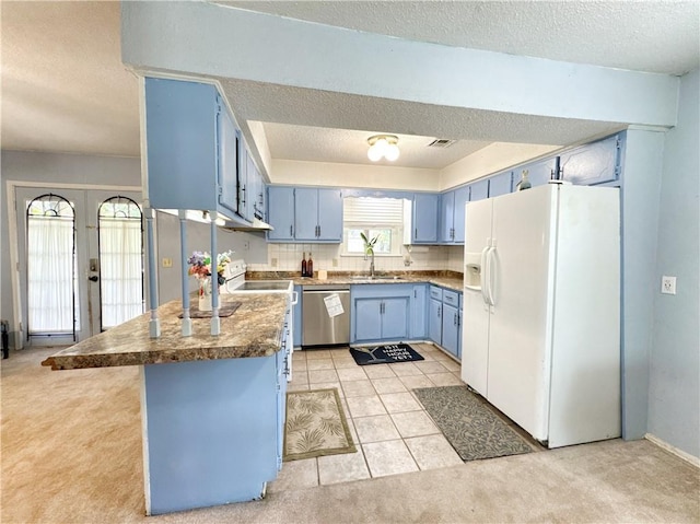 505 10th St, Bentonville, AR 72712 - kitchen featuring blue cabinetry, white appliances, light colored carpet, a peninsula, and a textured ceiling