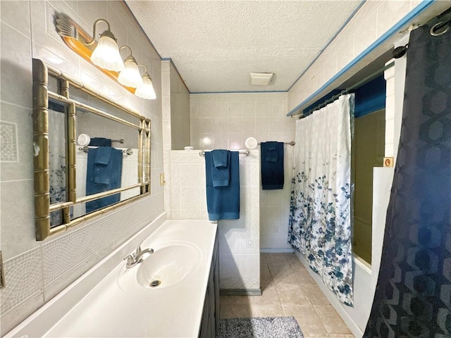 505 10th St, Bentonville, AR 72712 - bathroom with vanity, a textured ceiling, tile patterned flooring, shower / bath combination with curtain, and tile walls