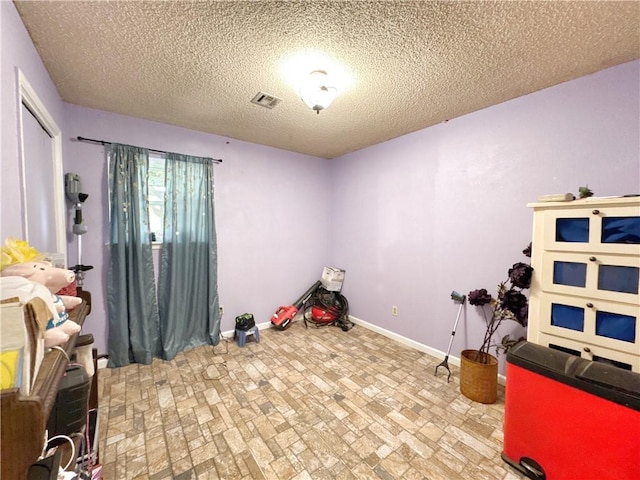 505 10th St, Bentonville, AR 72712 - rec room with brick patterned flooring, baseboards, and a textured ceiling