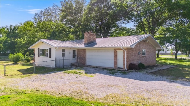 125 E Orchard Ln, Rogers, AR 72756 - ranch-style house with a chimney, metal roof, a standing seam roof, a garage, and gravel driveway