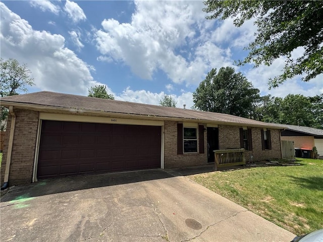 ranch-style house featuring brick siding, an attached garage, driveway, and a front yard