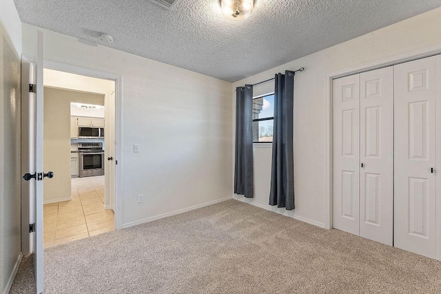 16 Eleanor Ln, Bella Vista, AR 72714 - unfurnished bedroom featuring light carpet, a closet, a textured ceiling, baseboards, and light tile patterned floors