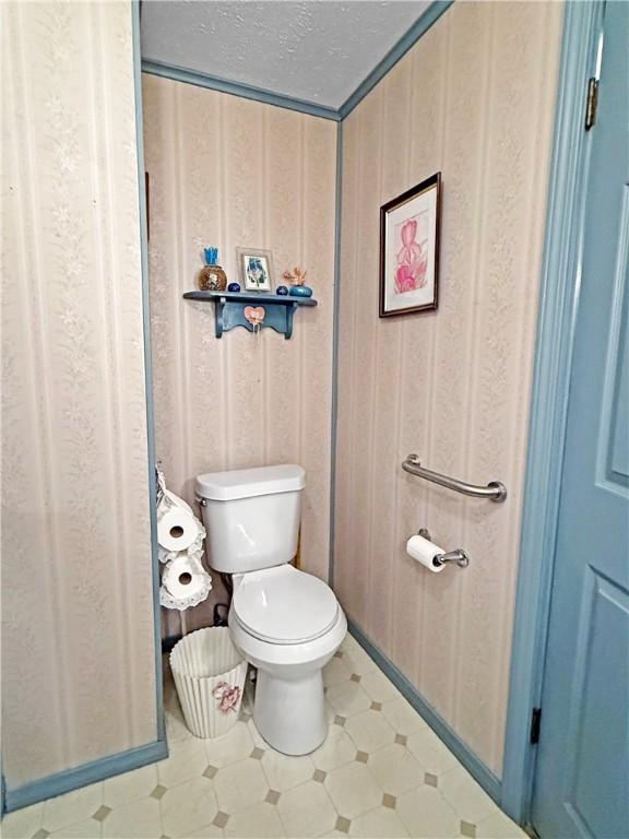 1711 W Cline Rd, Clarksville, AR 72830 - bathroom with toilet, a textured ceiling, and tile patterned floors