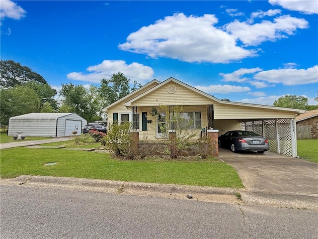 1711 W Cline Rd, Clarksville, AR 72830 - view of front of house with a front lawn, concrete driveway, an outdoor structure, a carport, and a porch