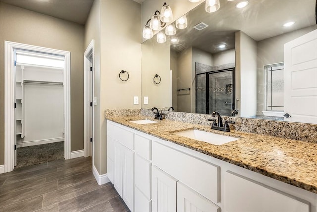 506 Hindman Dr, Prairie Grove, AR 72753 - bathroom with a shower stall, a walk in closet, double vanity, and baseboards
