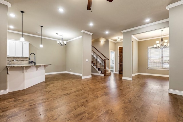 506 Hindman Dr, Prairie Grove, AR 72753 - unfurnished living room with a chandelier, stairway, ceiling fan, dark wood-type flooring, and recessed lighting