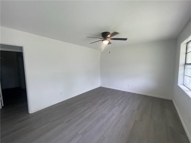 401 Walnut St, Clarksville, AR 72830 - spare room featuring ceiling fan, dark wood-type flooring, and baseboards