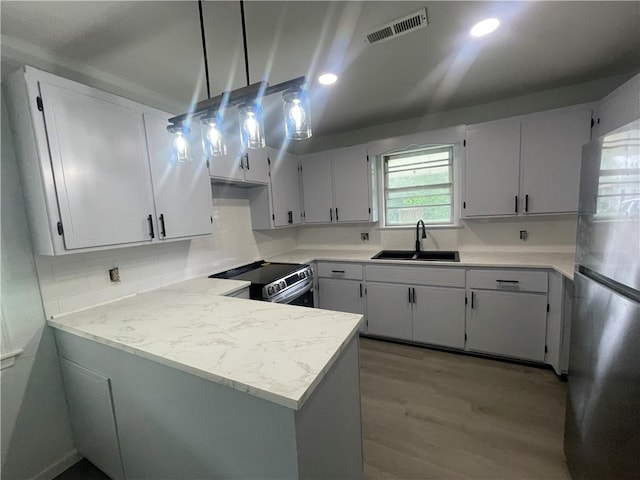 401 Walnut St, Clarksville, AR 72830 - kitchen featuring a sink, appliances with stainless steel finishes, light wood-type flooring, light countertops, and decorative backsplash