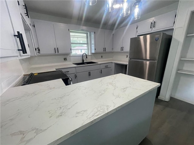401 Walnut St, Clarksville, AR 72830 - kitchen with freestanding refrigerator, a sink, a peninsula, black electric range oven, and light stone counters