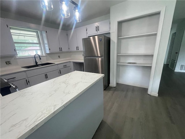 401 Walnut St, Clarksville, AR 72830 - kitchen with freestanding refrigerator, a sink, dark wood finished floors, and light stone countertops