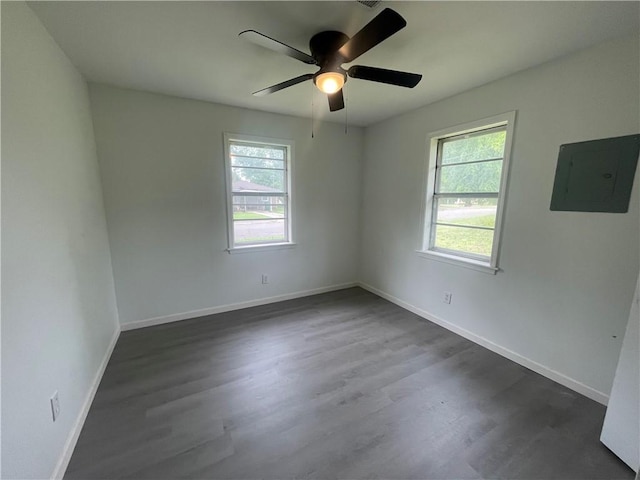 401 Walnut St, Clarksville, AR 72830 - spare room featuring electric panel, ceiling fan, dark wood finished floors, and baseboards