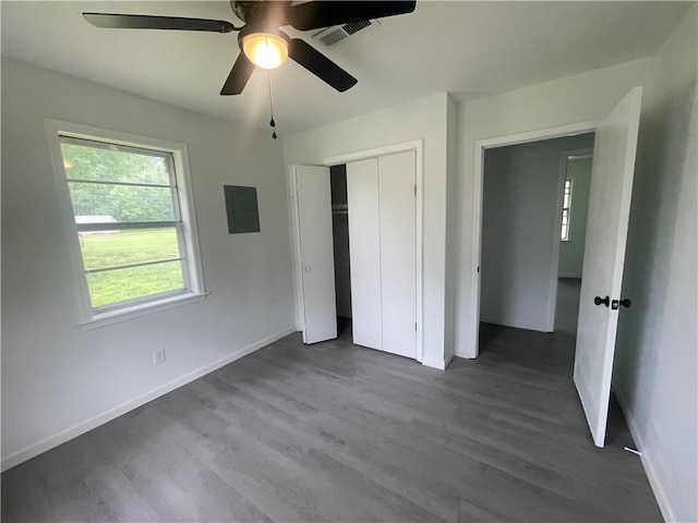 401 Walnut St, Clarksville, AR 72830 - unfurnished bedroom featuring electric panel, baseboards, dark wood-style flooring, and a closet