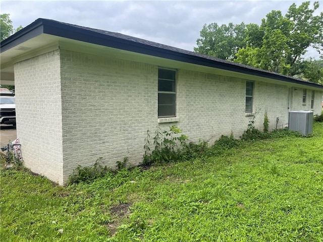 401 Walnut St, Clarksville, AR 72830 - view of side of home featuring central AC, brick siding, and a yard
