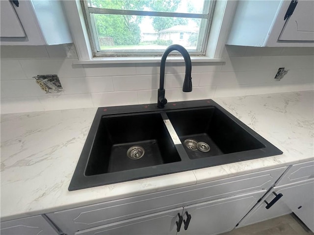 401 Walnut St, Clarksville, AR 72830 - kitchen view of backsplash, white cabinets, and light stone countertops