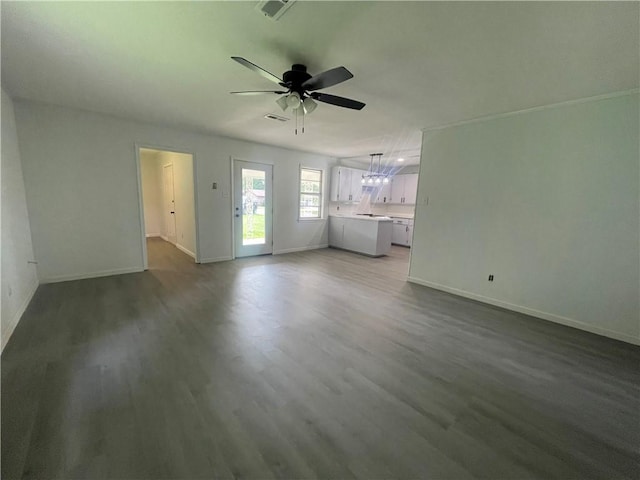 401 Walnut St, Clarksville, AR 72830 - unfurnished living room featuring baseboards, a ceiling fan, and wood finished floors