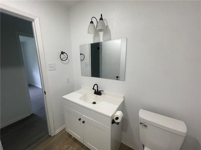 401 Walnut St, Clarksville, AR 72830 - half bathroom featuring wood finished floors, vanity, toilet, and baseboards