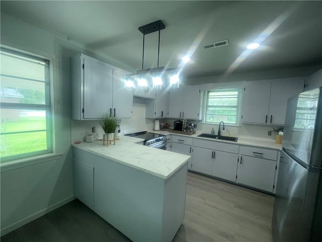 401 Walnut St, Clarksville, AR 72830 - kitchen featuring freestanding refrigerator, electric range, white cabinetry, a peninsula, and light countertops