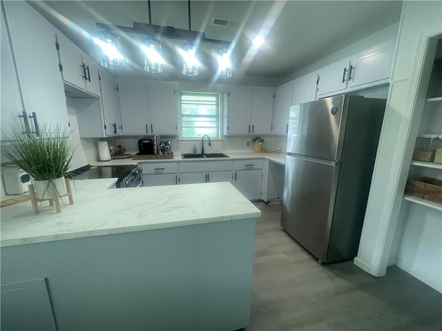 401 Walnut St, Clarksville, AR 72830 - kitchen with stainless steel appliances, a peninsula, and white cabinets