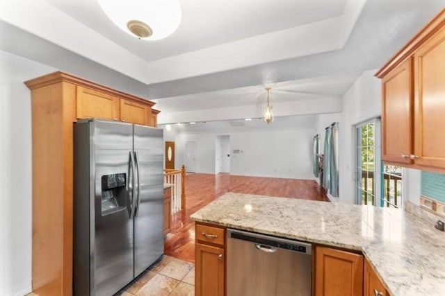 1878 Morning Side Falls Blvd, Blue Eye, MO 65611 - kitchen featuring appliances with stainless steel finishes, a peninsula, a tray ceiling, open floor plan, and light stone counters