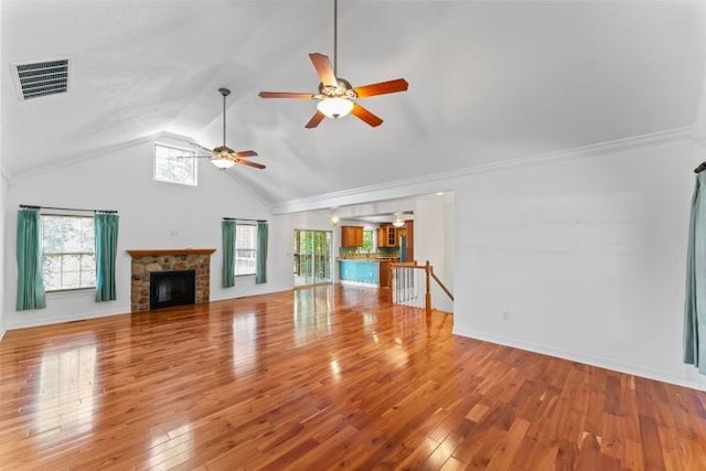 1878 Morning Side Falls Blvd, Blue Eye, MO 65611 - unfurnished living room featuring a ceiling fan, a stone fireplace, wood-type flooring, high vaulted ceiling, and baseboards