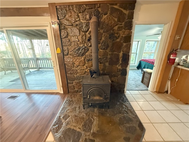 1088 Little Red River Rd, Leslie, AR 72645 - unfurnished living room featuring healthy amount of natural light, a wood stove, and light tile patterned floors