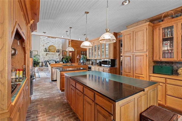 24 Dogwood Rdg, Eureka Springs, AR 72632 - kitchen featuring brick floors, appliances with stainless steel finishes, dark countertops, a kitchen island, and glass insert cabinets