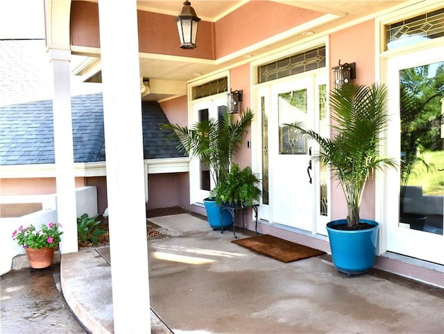 8141 Ward Ln, Rogers, AR 72756 - view of exterior entry with a porch, stucco siding, and roof with shingles