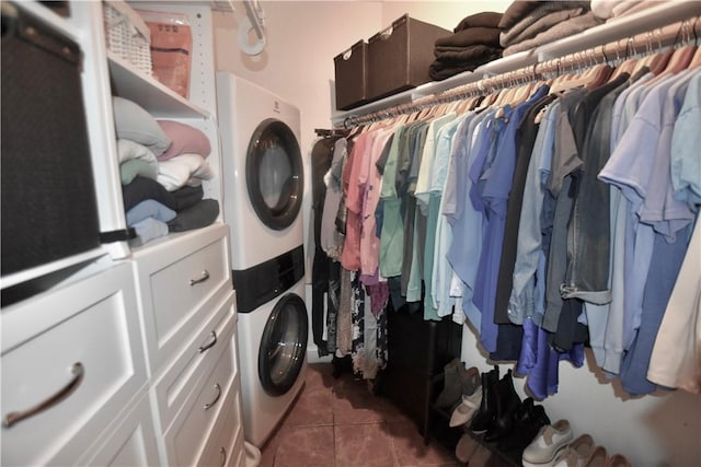 8141 Ward Ln, Rogers, AR 72756 - laundry area with stacked washing machine and dryer, tile patterned floors, and cabinet space