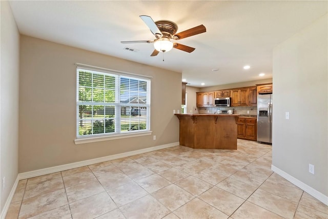 708 Carter Ct, Siloam Springs, AR 72761 - kitchen with appliances with stainless steel finishes, a peninsula, recessed lighting, light tile patterned floors, and a breakfast bar