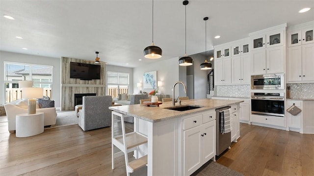 1404 Breeze Ct, Bentonville, AR 72713 - kitchen with appliances with stainless steel finishes, a sink, light wood-style floors, plenty of natural light, and recessed lighting