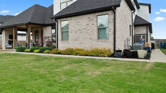 1404 Breeze Ct, Bentonville, AR 72713 - view of home's exterior with a yard, central air condition unit, brick siding, roof with shingles, and board and batten siding