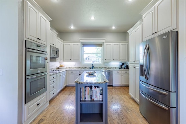 2507 NW Linebarger Ln, Bentonville, AR 72712 - kitchen with appliances with stainless steel finishes, a sink, light stone counters, white cabinets, and recessed lighting