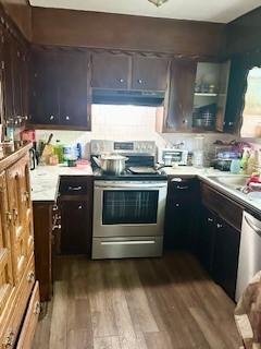 410 E Harvard St, Siloam Springs, AR 72761 - kitchen featuring stainless steel appliances, under cabinet range hood, dark wood finished floors, light countertops, and dark brown cabinets