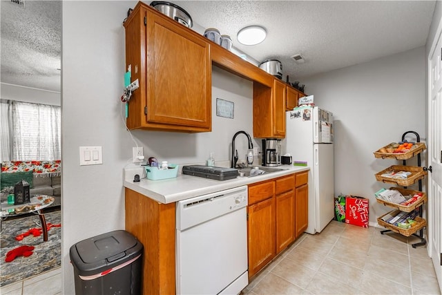 3408 SW Victoria Pl, Bentonville, AR 72712 - kitchen with white appliances, a textured ceiling, light countertops, brown cabinets, and light tile patterned flooring