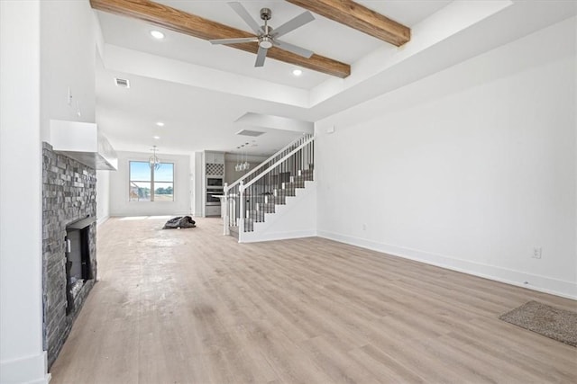 6601 SW Acacia St, Bentonville, AR 72713 - unfurnished living room with stairway, light wood finished floors, a stone fireplace, a ceiling fan, and beamed ceiling